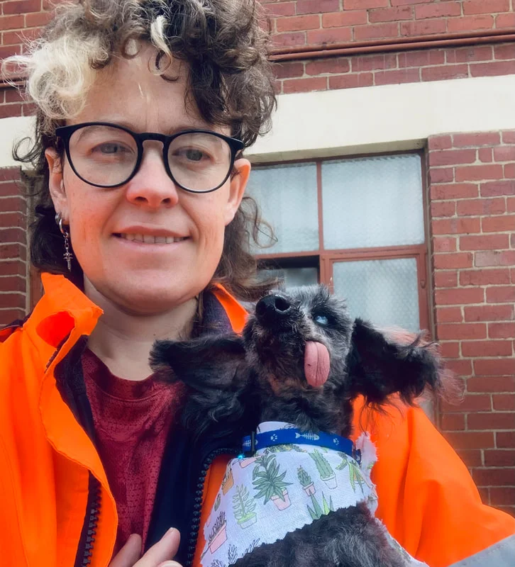 Chi Chi, owner of Poochi Grooming, holding a happy senior dog